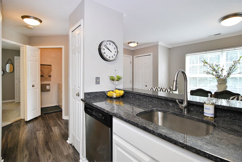 a kitchen with a sink and a clock
