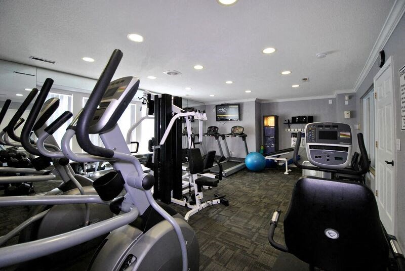 A gym with treadmills, elliptical machines, and other exercise equipment.