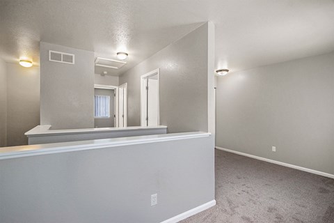 an empty living room with a white wall and a window