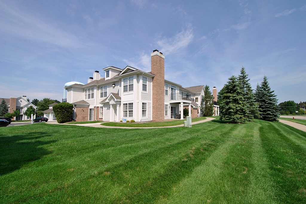 a large white house with a lawn in front of it