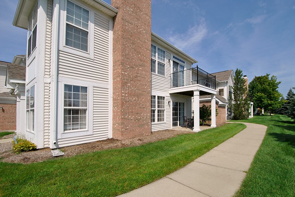 an apartment building with a sidewalk in front of it