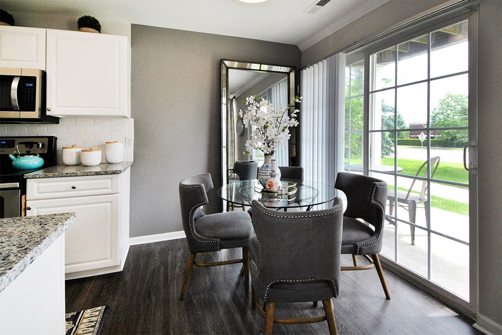 a kitchen and dining room with a table and chairs and a large window
