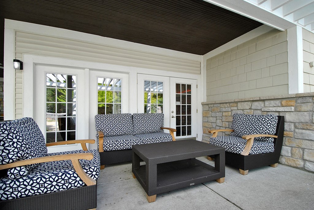 a covered patio with chairs and a coffee table