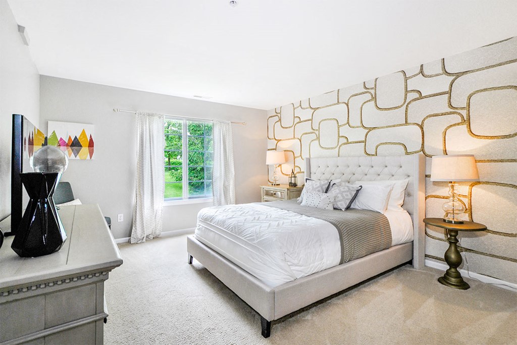 a bedroom with a bed and a wall with a geometric design