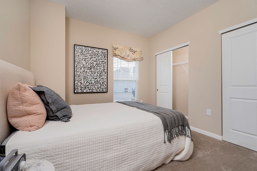 a bedroom with a bed and a door to a closet