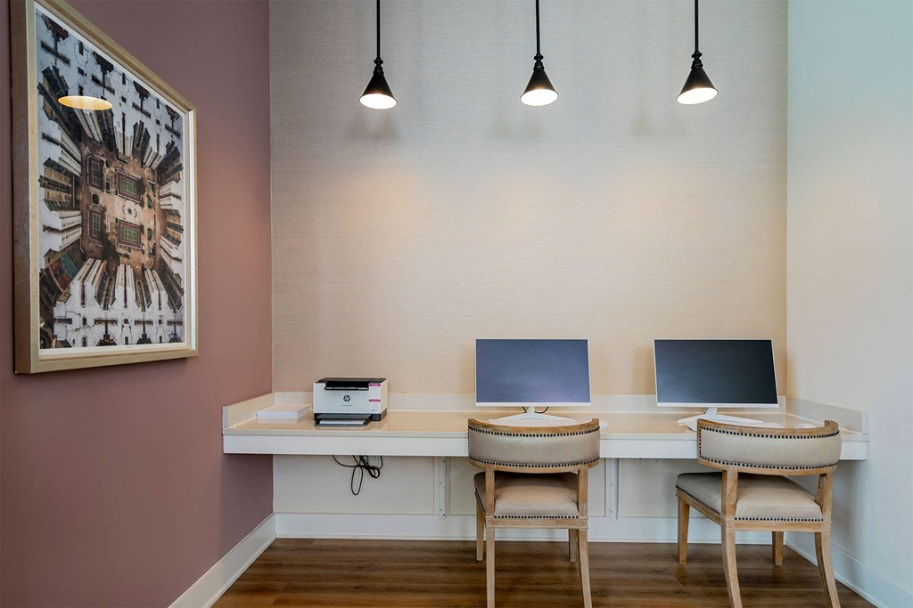 a home office with two desks and two chairs and a painting on the wall
