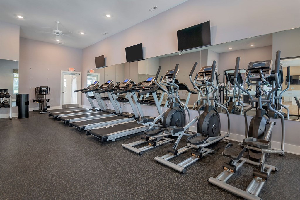 a row of treadmills and other exercise equipment in a gym