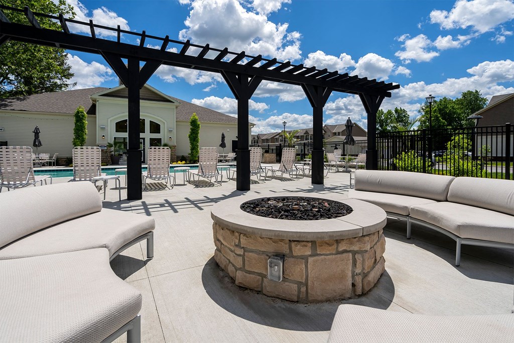 an outdoor patio with couches and chairs around a fire pit