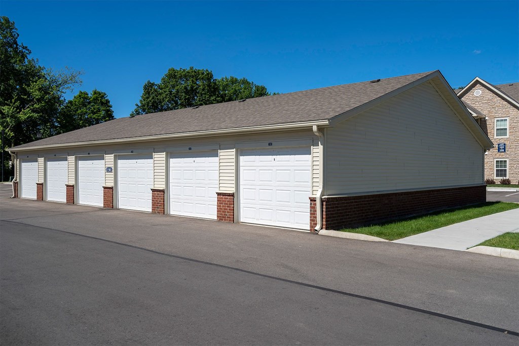 a row of white garage doors on the side of a building