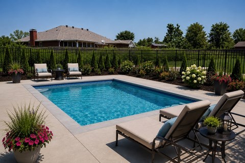 A pool surrounded by chairs and plants.