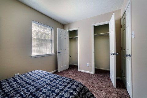 A bedroom with a bed and a window.