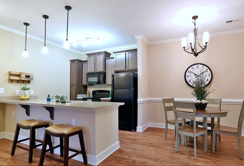 A kitchen with a bar area and a dining table.