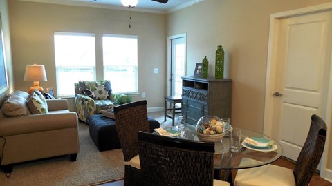 A living room with a couch, chair, and dining table.