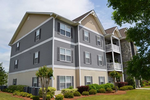 A large apartment building with a balcony on the second floor.