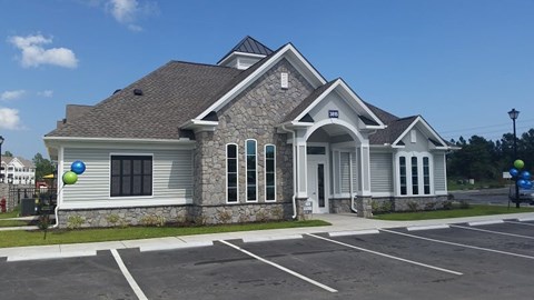 A small building with a parking lot in front.