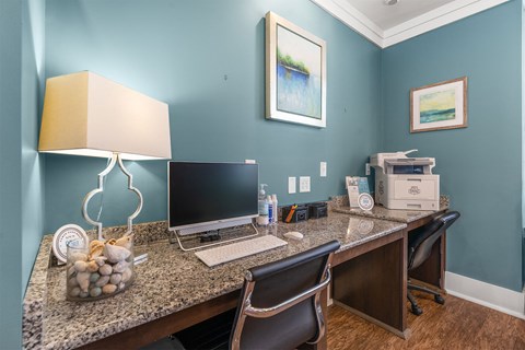 A desk with a laptop and a printer on it.