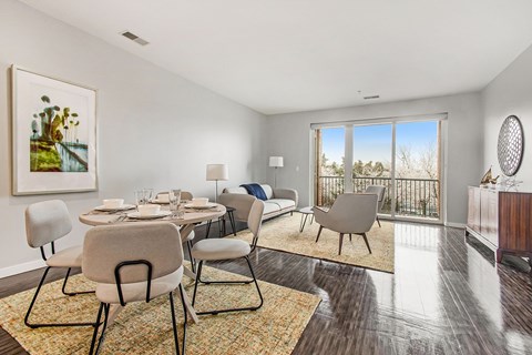 A dining room with a table set for six and a view of the outdoors.