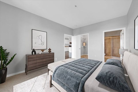 A bedroom with a large bed and a dresser.