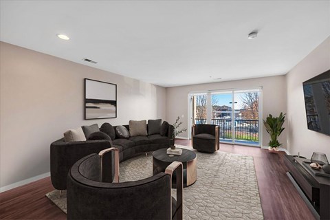 A living room with a black couch and a television.
