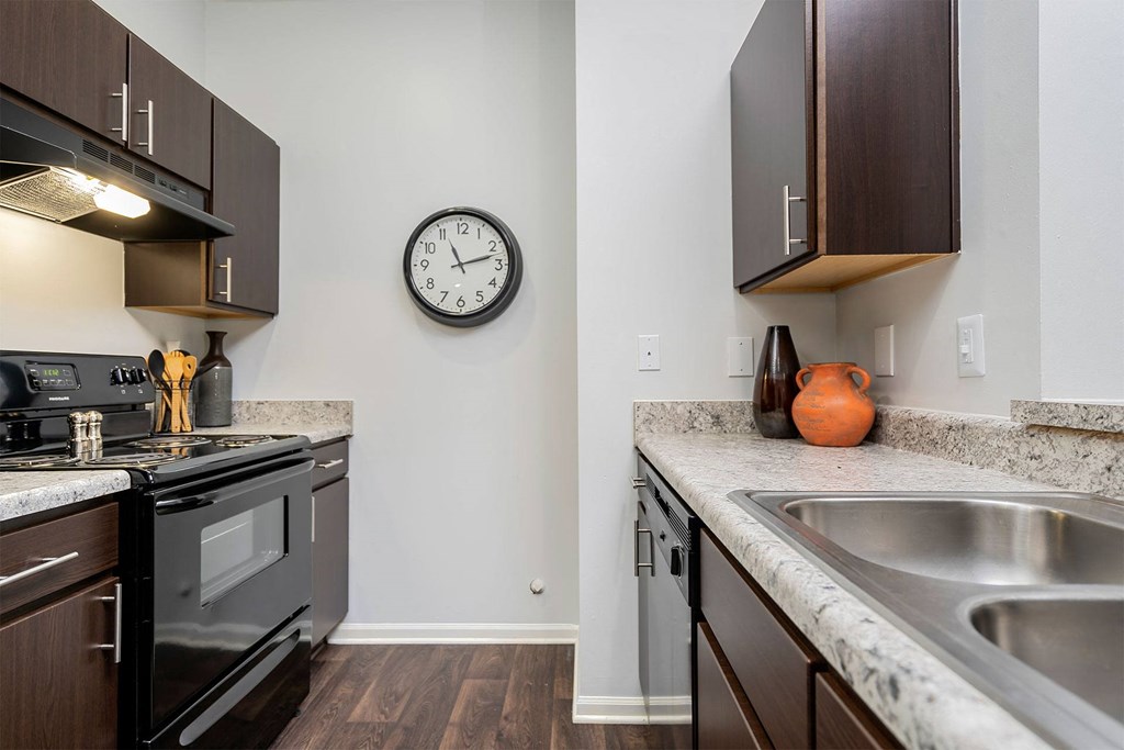 a kitchen with stainless steel appliances and a clock on the wall