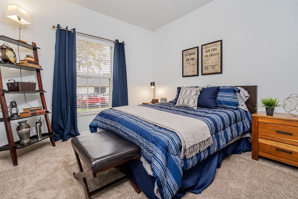 a bedroom with a bed and a window with blue curtains