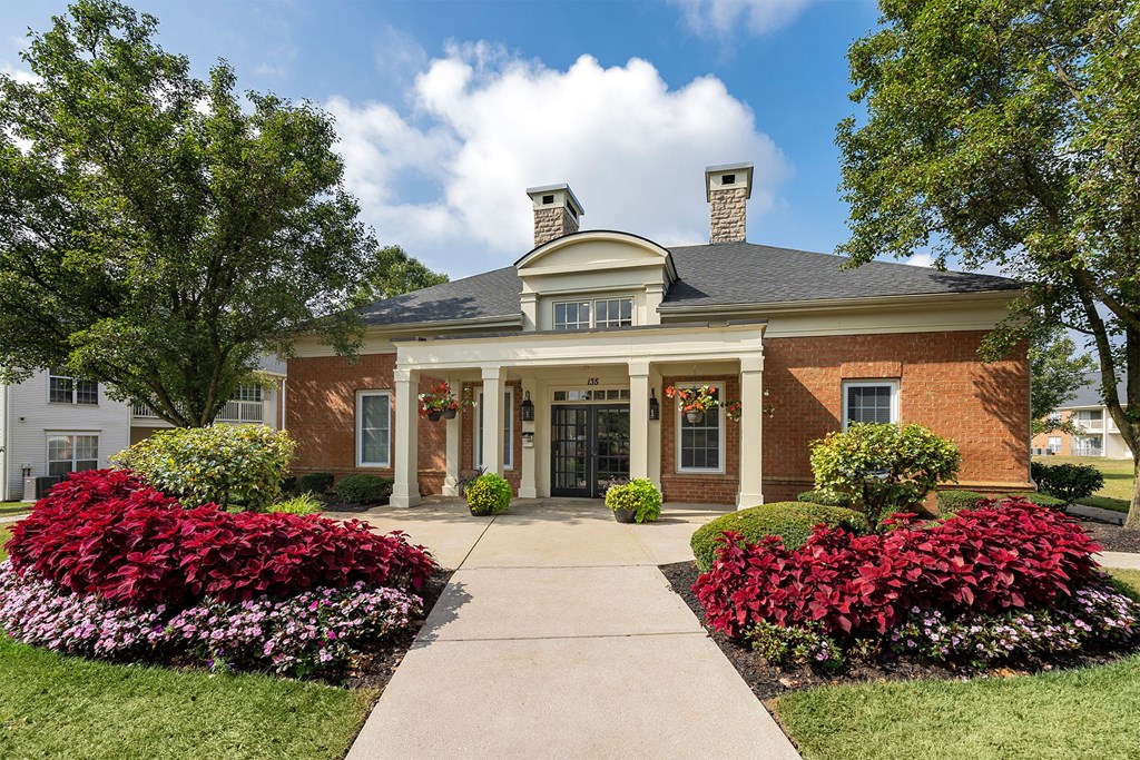 the front of a brick house with a walkway and landscaping