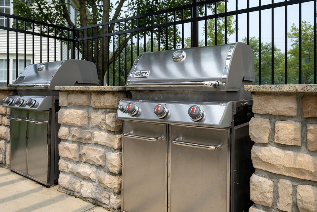 a stainless steel barbecue with two bbq grills and two stoves in front of