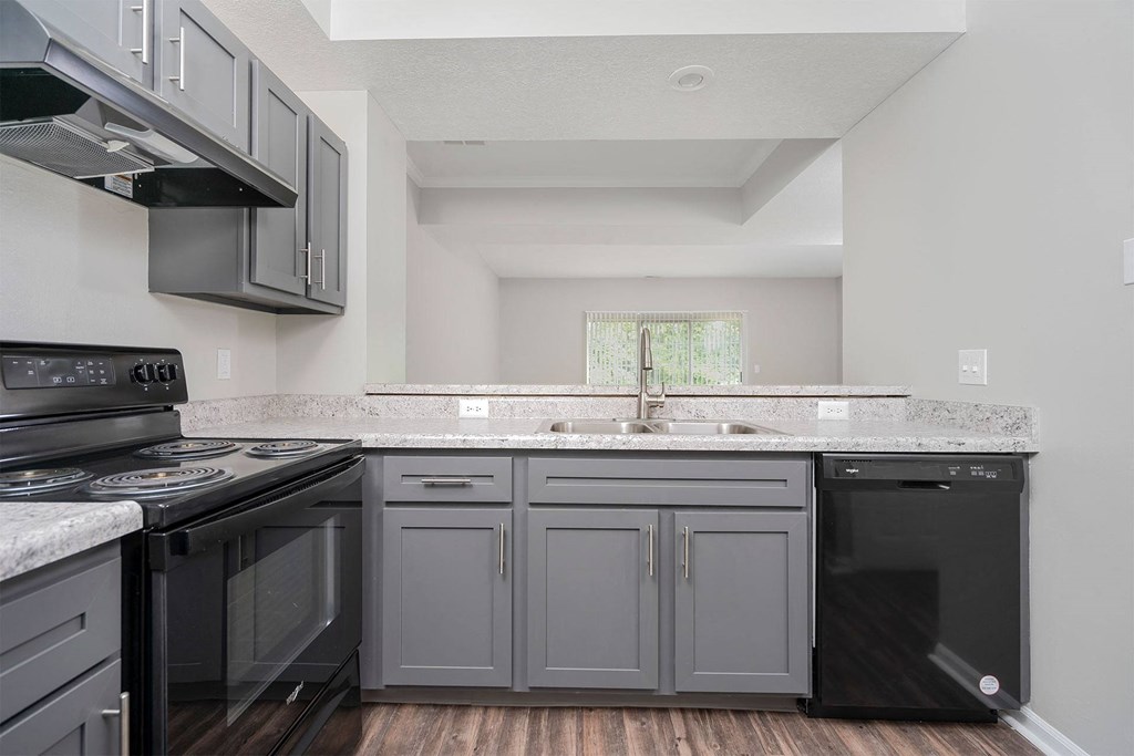 a kitchen with gray cabinets and black appliances