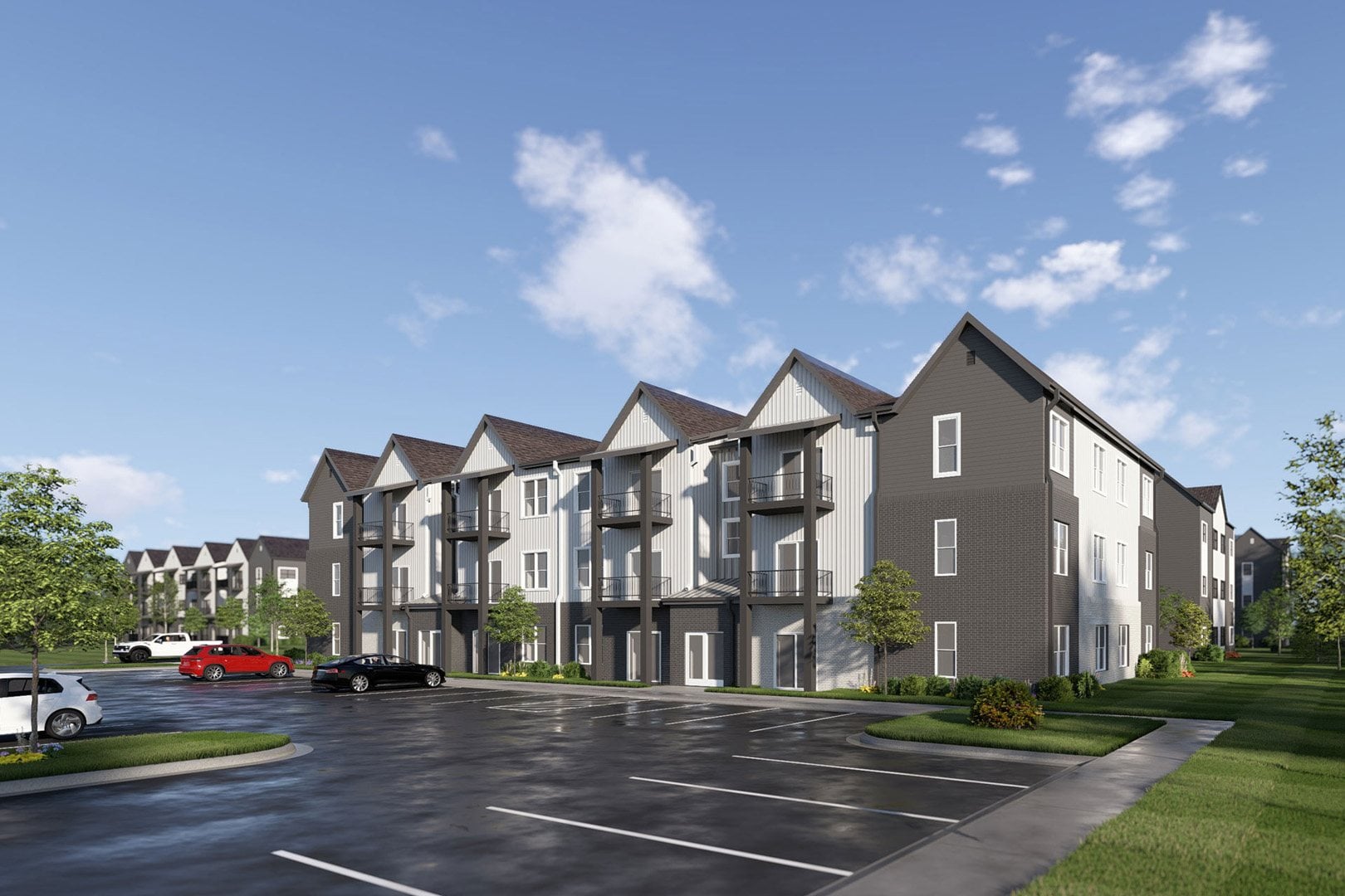 A large apartment complex with a parking lot in front.