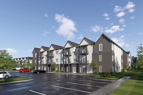 A large apartment complex with a parking lot in front.