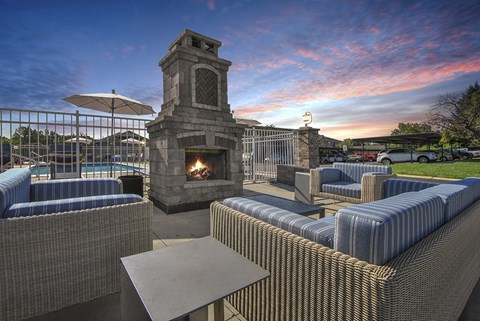 A patio with a fireplace and seating area.
