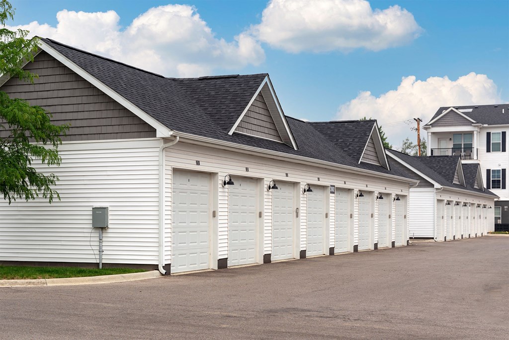 a row of white garage doors on the side of a building