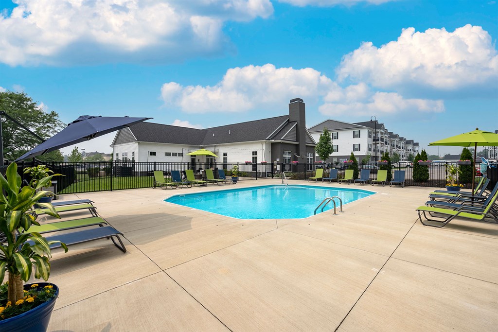 our apartments have a large swimming pool with chairs and umbrellas