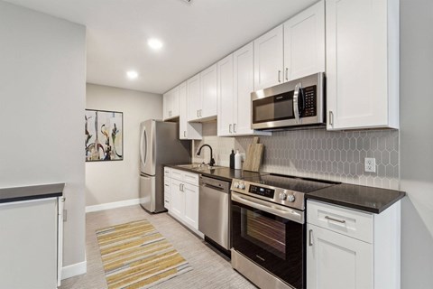 A kitchen with white cabinets and stainless steel appliances.