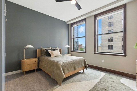 A bedroom with a bed, nightstand, and window.