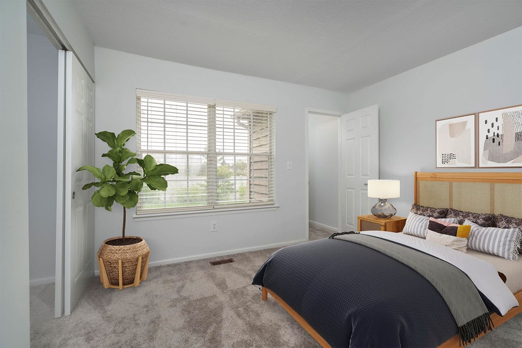 a bedroom with a bed and a potted plant