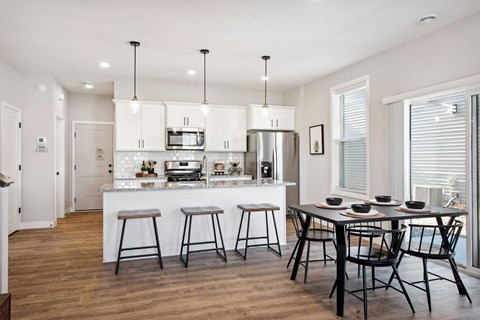 an open kitchen and dining area with a table and chairs