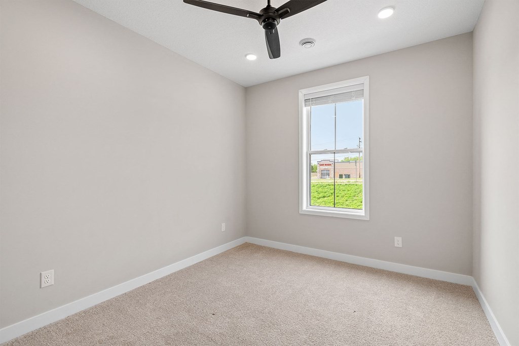 a bedroom with a ceiling fan and a window