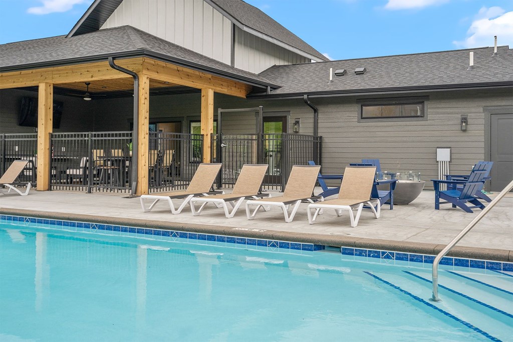 a swimming pool with chaise lounge chairs and a building in the background