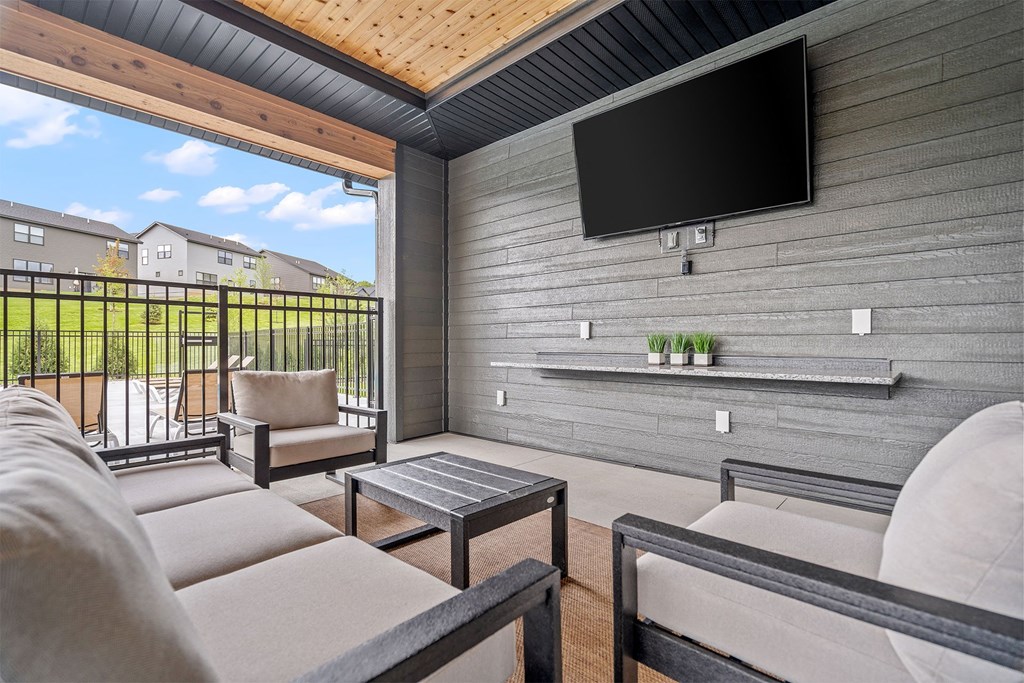 a patio with a couch and a coffee table in front of a tv