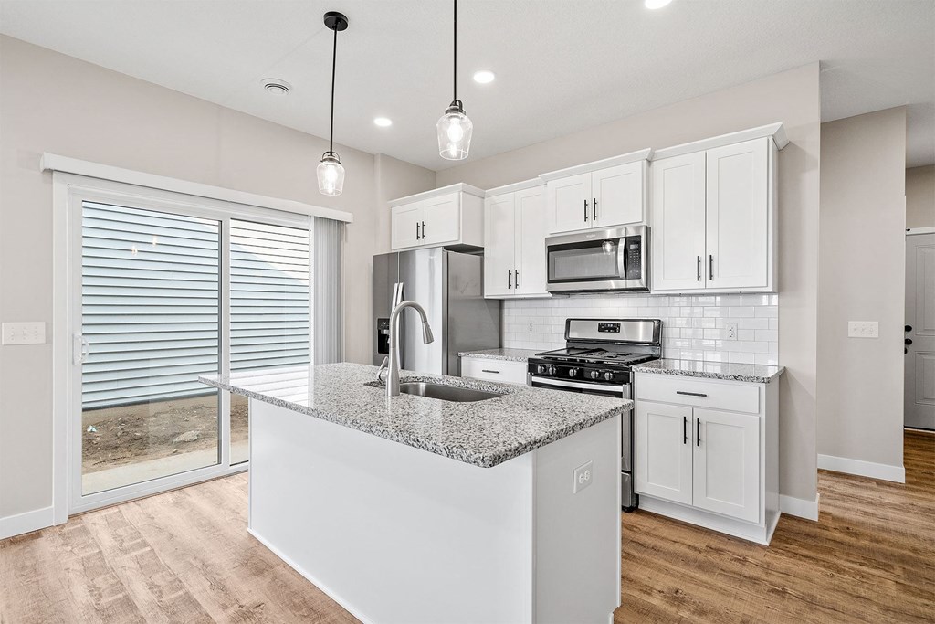 a kitchen with white cabinets and a granite counter top