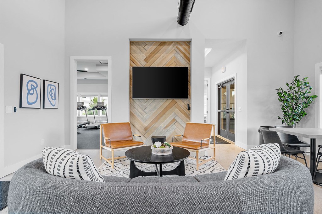 a living room with a gray couch and two orange chairs