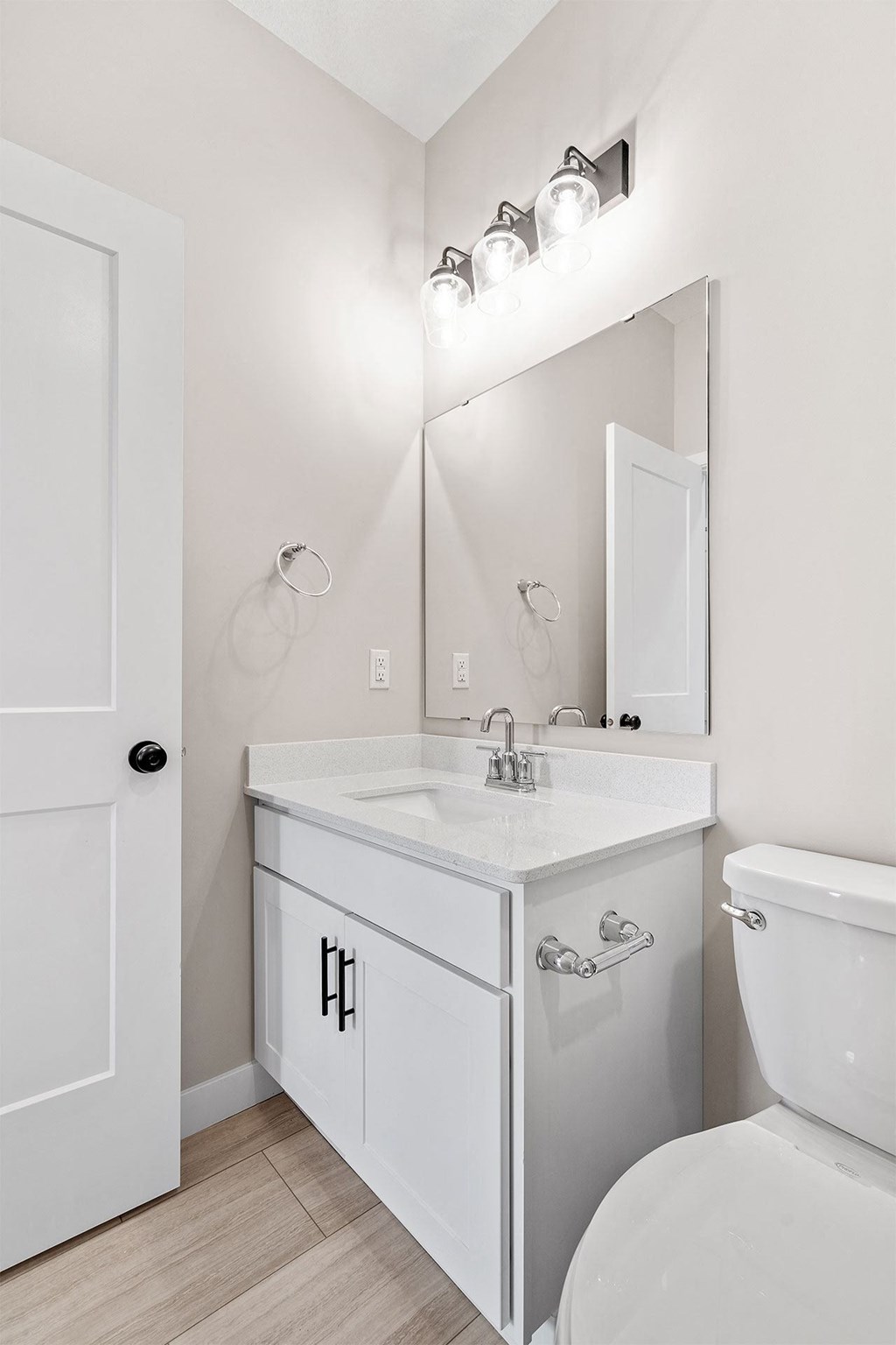 a bathroom with a white sink and toilet and a white door
