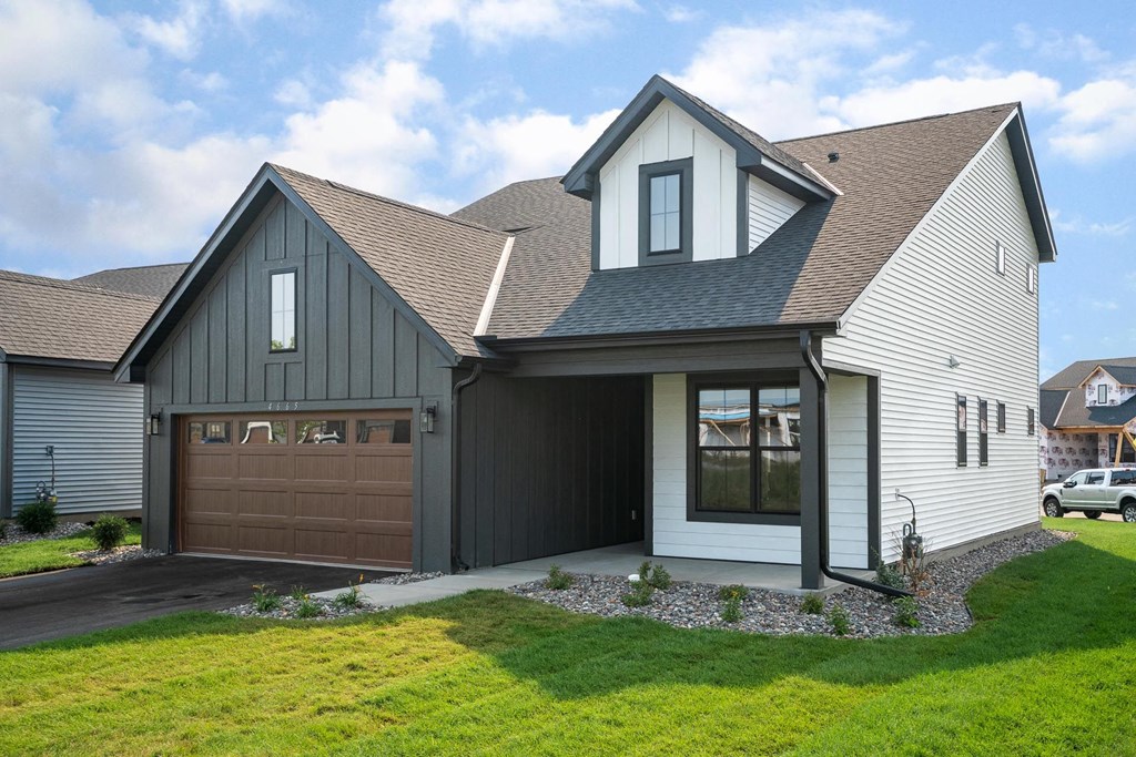 a house with a gray roof and a brown garage door