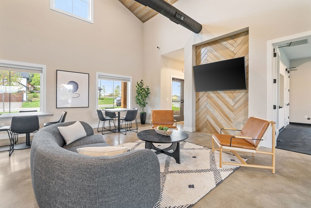 a living room with a couch and chairs and a tv