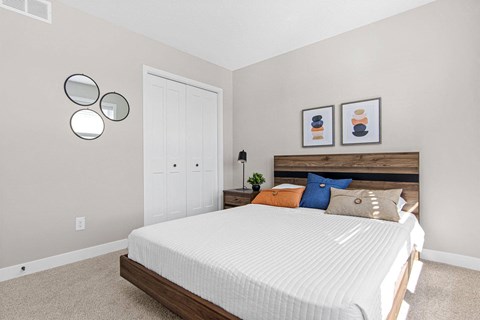 a bedroom with a white bed and two mirrors on the wall
