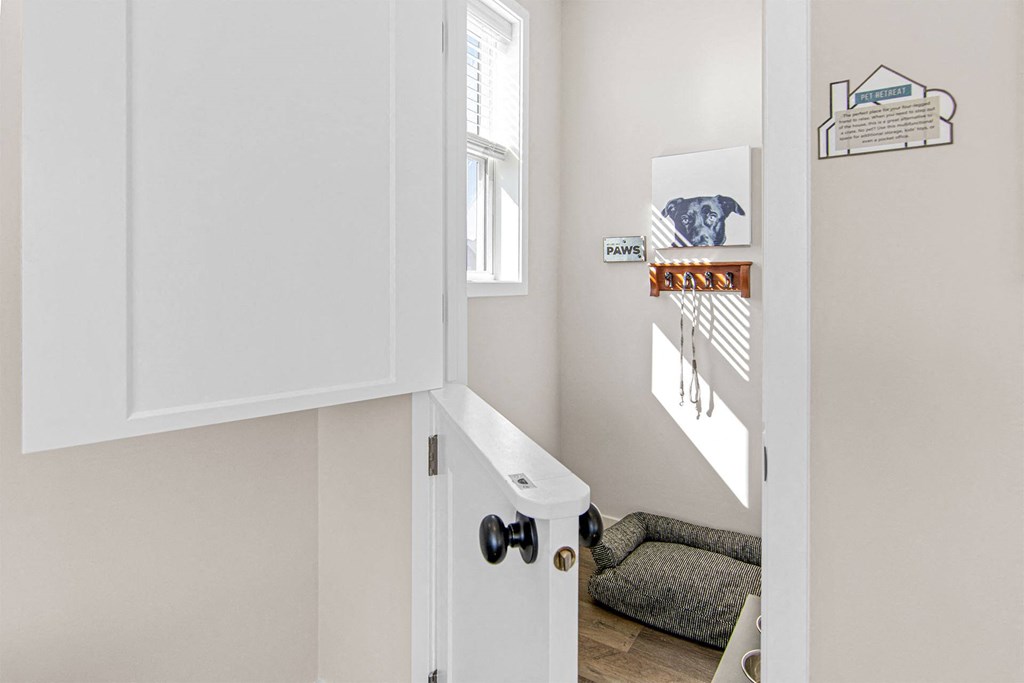 a small laundry room with white cabinets and a gray couch