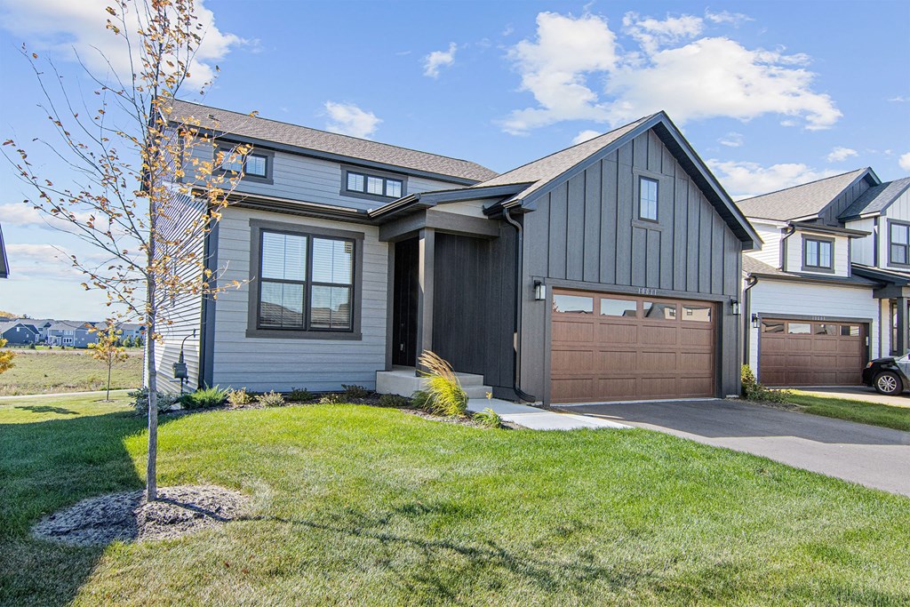 a house with gray siding and a brown garage door
