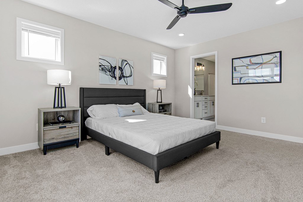 a bedroom with a bed and a ceiling fan