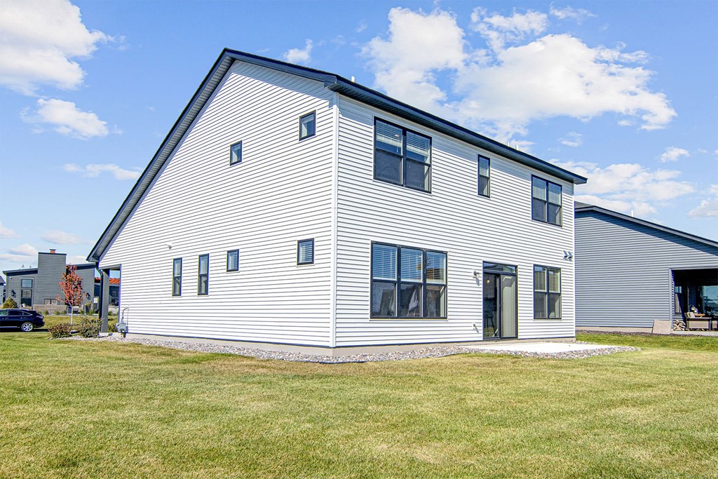 a white house with a black roof and white siding